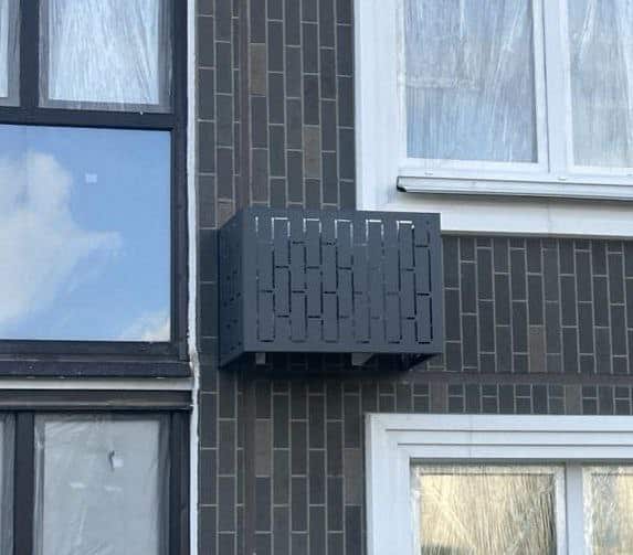 Корзина для кондиционера на фасаде здания.